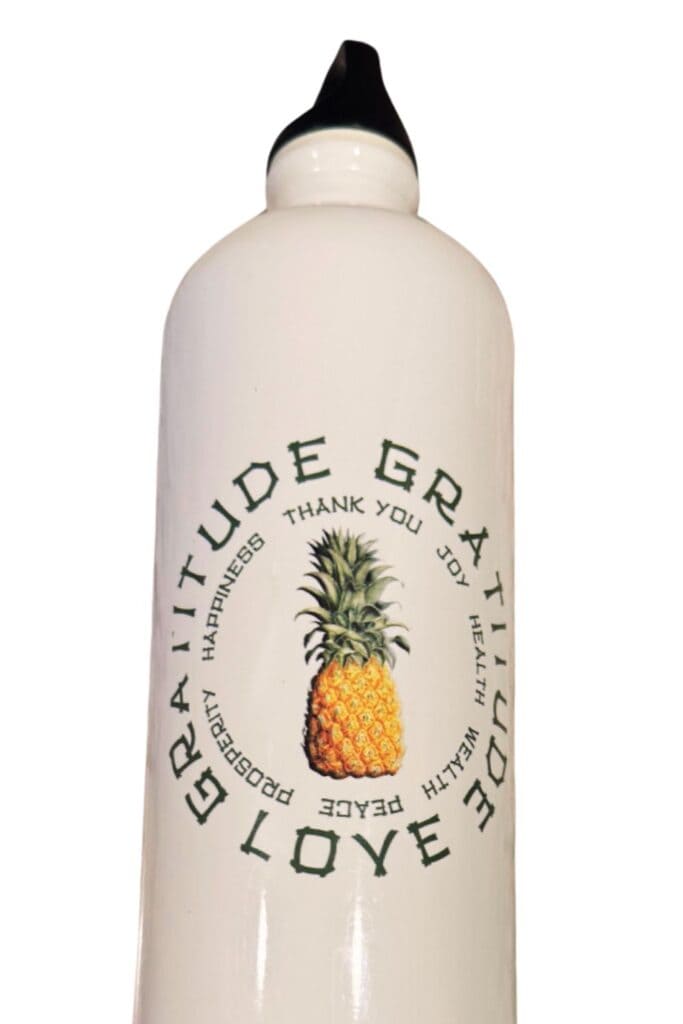 White water bottle with the words “Love Gratitude Joy” and a gold pineapple design