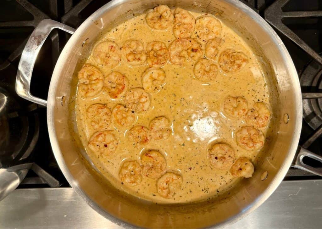 Creamy Cajun shrimp simmering in a rich butter sauce in a skillet