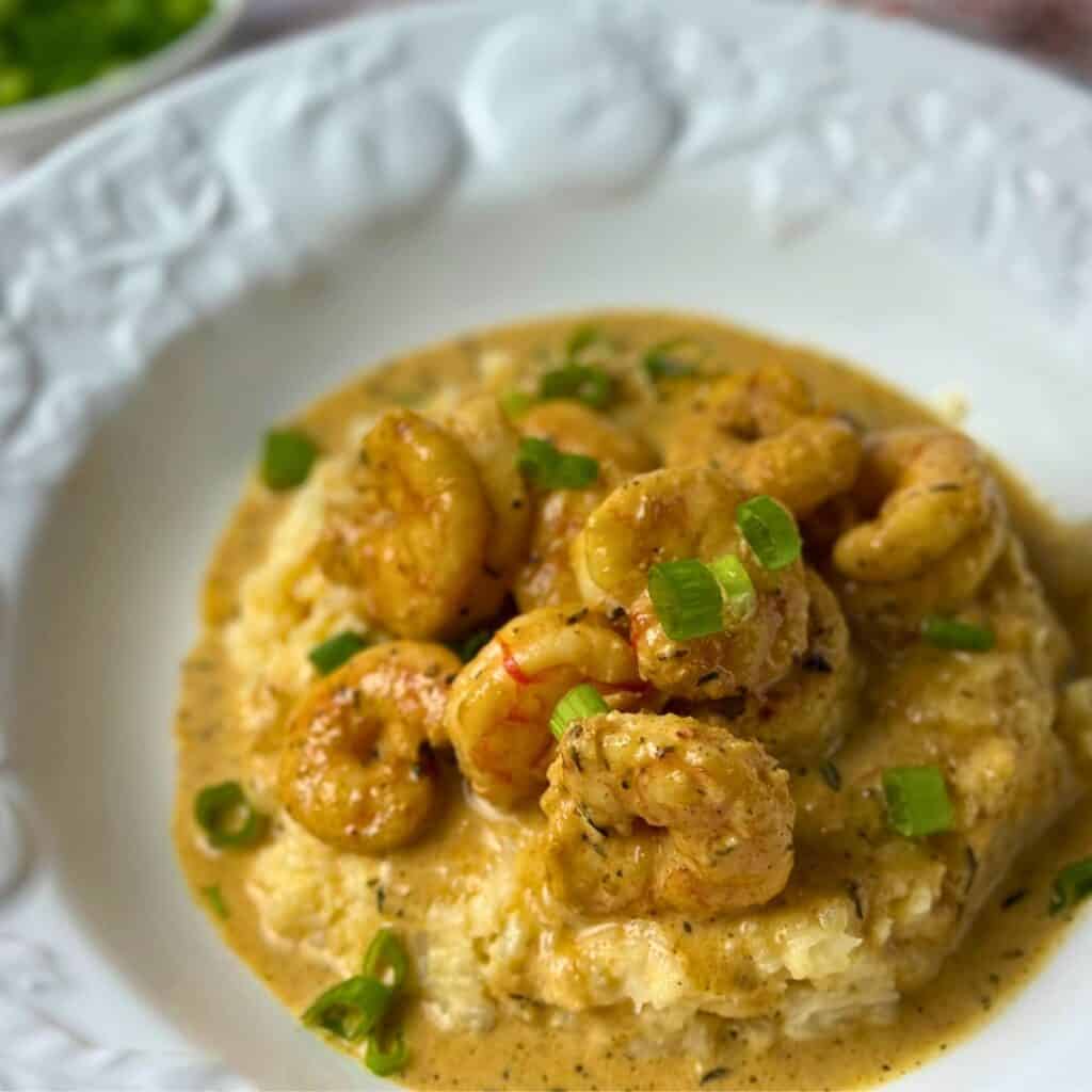 Keto Cajun Shrimp and Cheesy Grits served over creamy cauliflower grits with a rich Creole-inspired sauce.