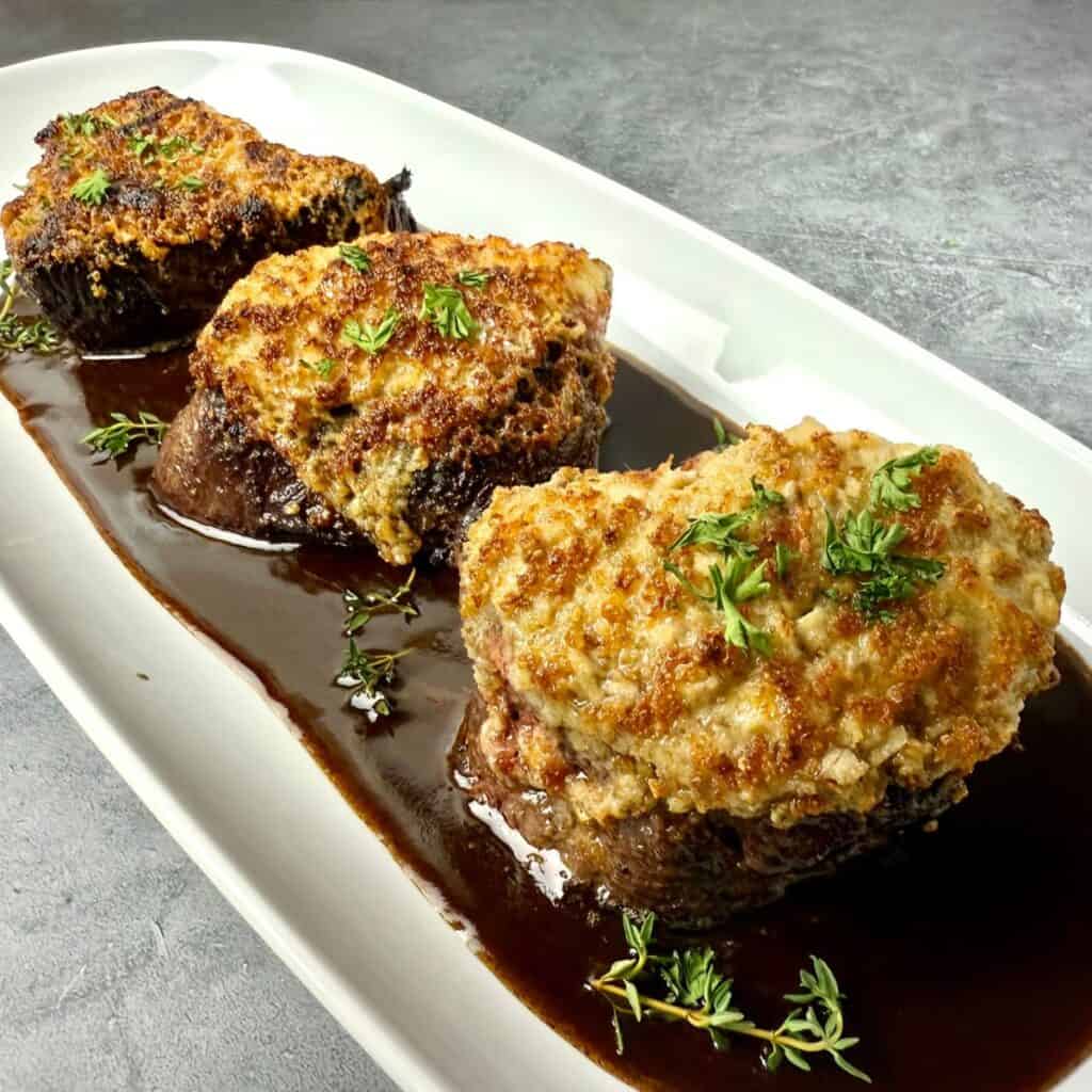 Trio of Wildfire-style crusted steak medallions with Parmesan, horseradish, and mushroom crusts on a white platter